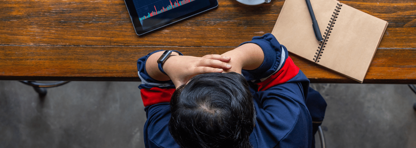 person at a desk with ipad and notebook